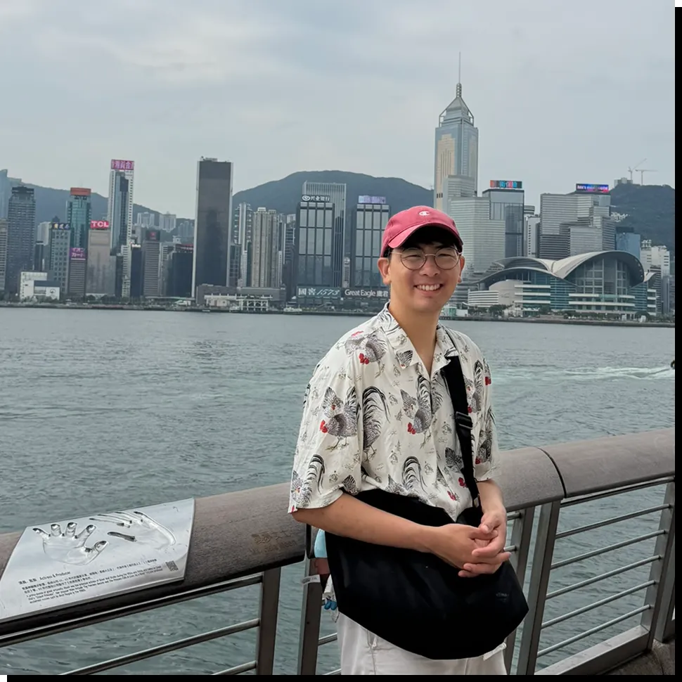 Darren at the waterfront with a city skyline behind him