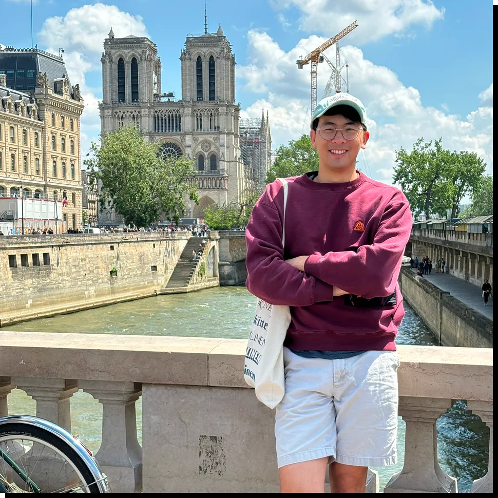 Darren on a bridge in Paris with Notre-Dame behind him